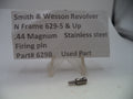 A small metal firearm firing pin part displayed on a clear plastic stand in front of a white paper label that reads 'Smith & Wesson Revolver N Frame 629-5 & Up .44 Magnum Stainless steel Firing pin Part# 629B Used Part'.