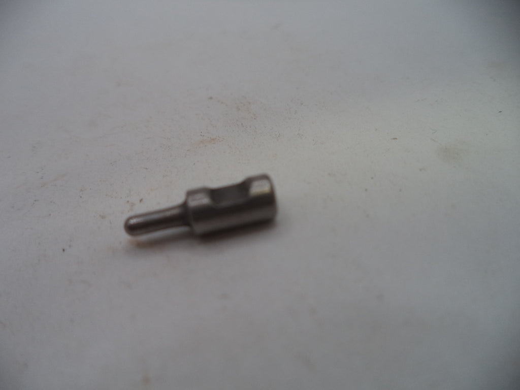 A small metallic cylindrical pin or connector with a flat head, shown on a plain off-white surface.