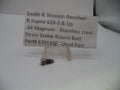 A small metal strain screw part displayed on a clear plastic stand in front of a white paper label that reads 'Smith & Wesson Revolver N Frame 629-5 & Up .44 Magnum Stainless steel Strain Screw Round Butt Part# 629141E Used Part'.