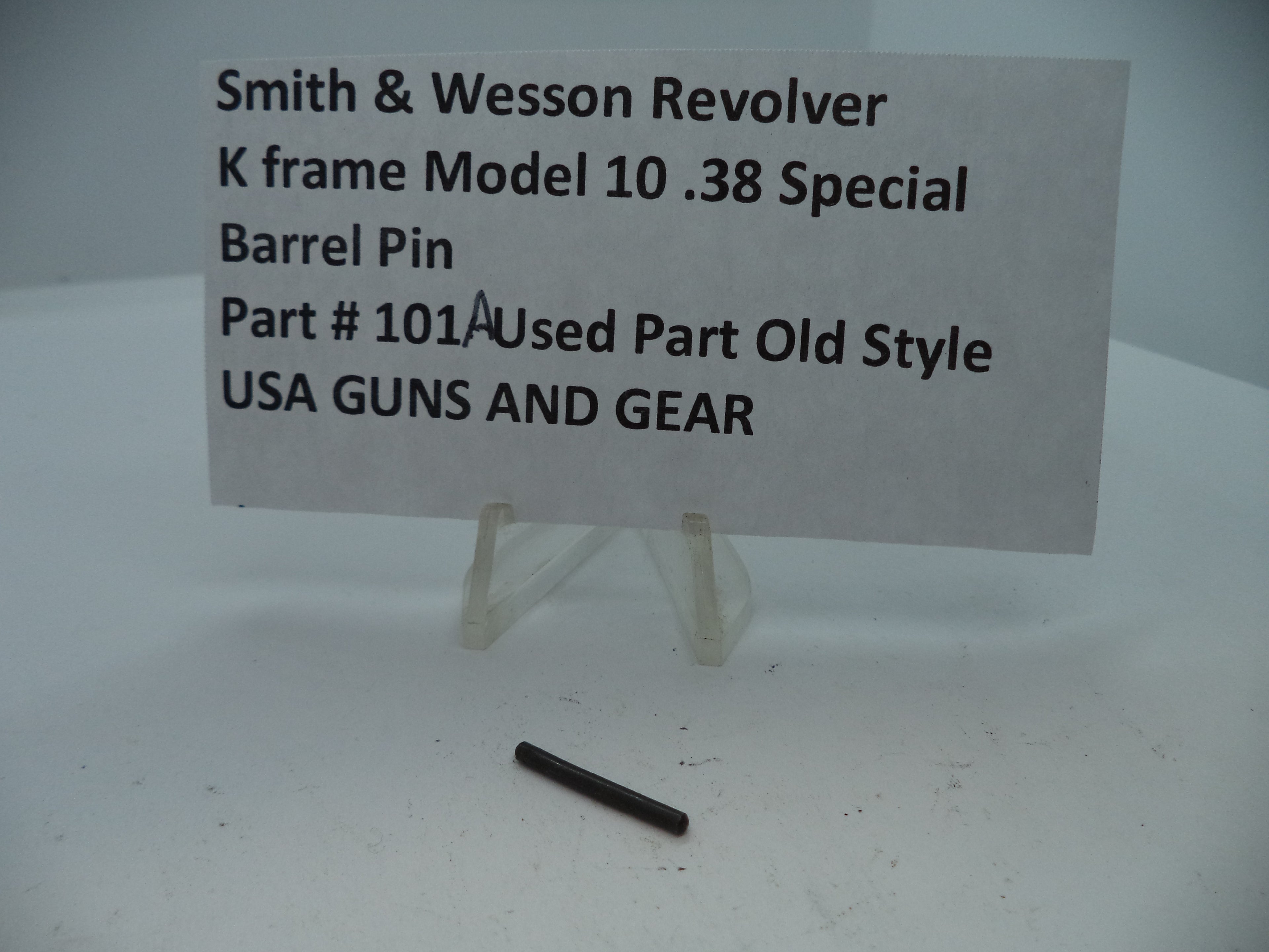 A sign displaying Smith & Wesson K Frame Model 1038 Special used part old style, with a barrel pin listed as Part #101A. The sign has a white background with printed text and a picture of the part.