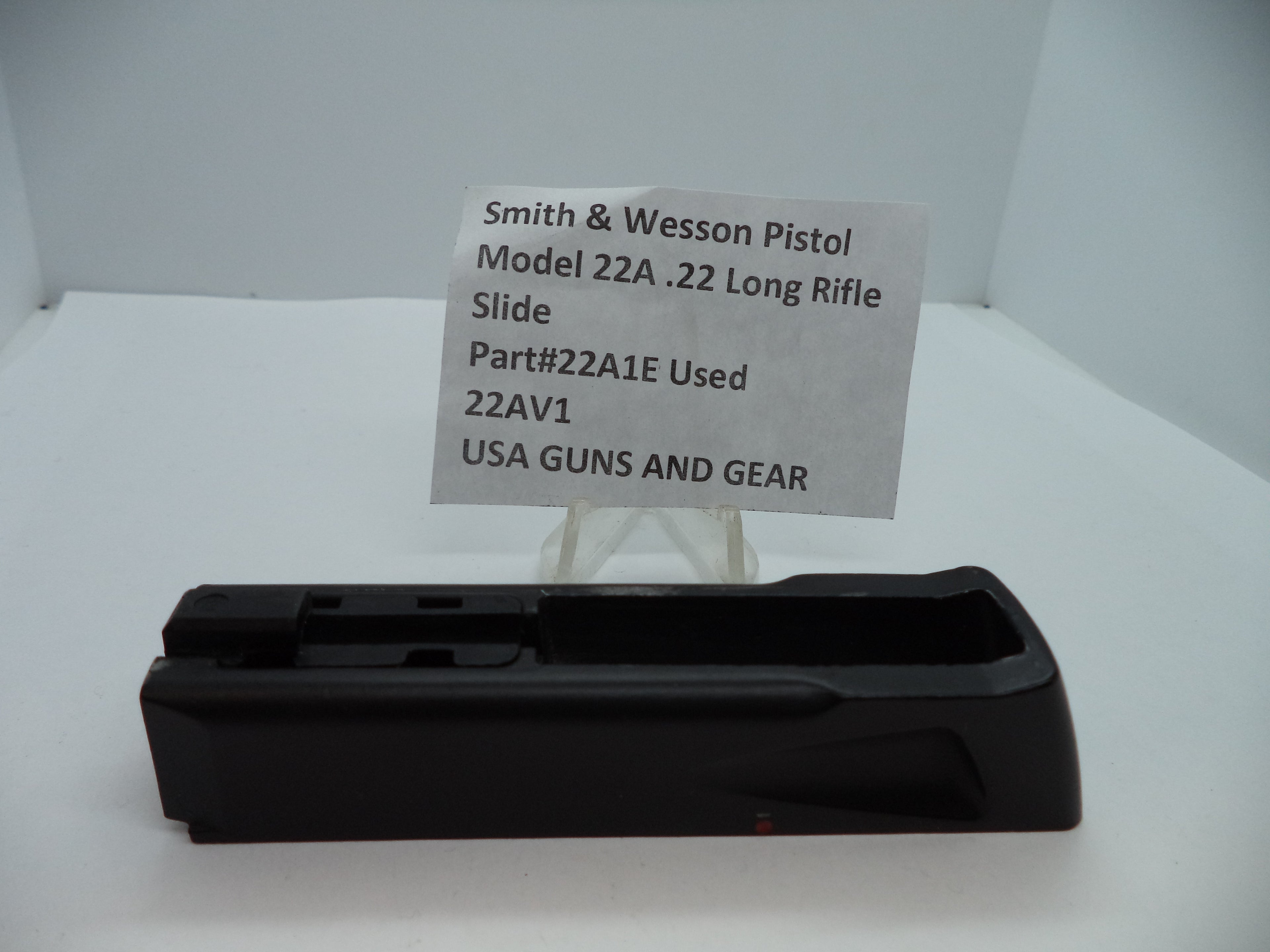 Smith & Wesson Pistol Model 22A Slide .22 Long Rifle used part displayed on a white stand with a label describing the product.