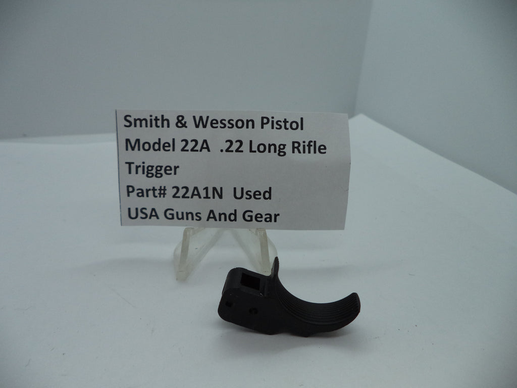 Smith & Wesson Pistol Model 22A Trigger .22 Long Rifle used part displayed on a white background with a descriptive label in front.