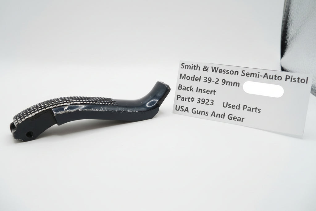 Black gun part with a label for Smith & Wesson semi-auto pistol on a white background