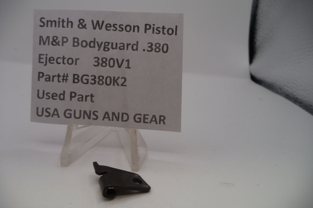Black gun part with a label on a white background