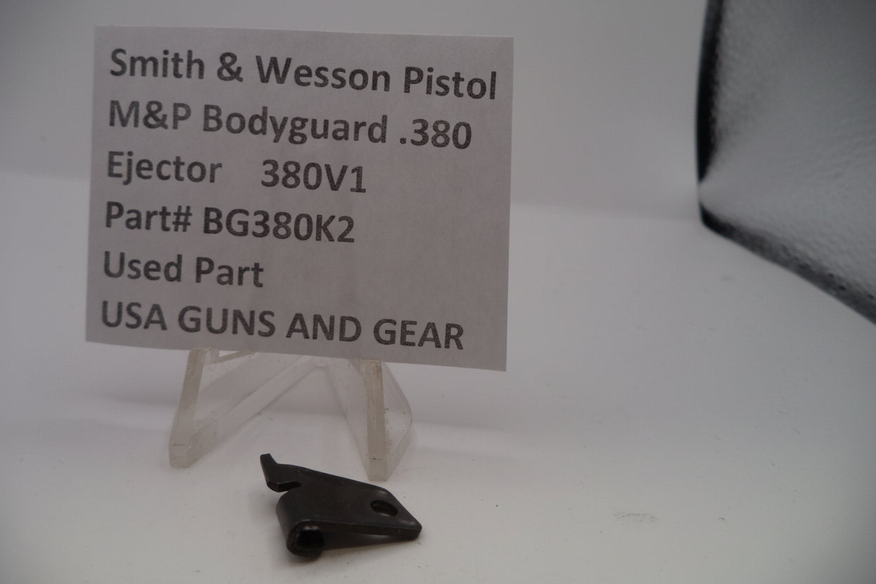 Black gun part with a label on a white background