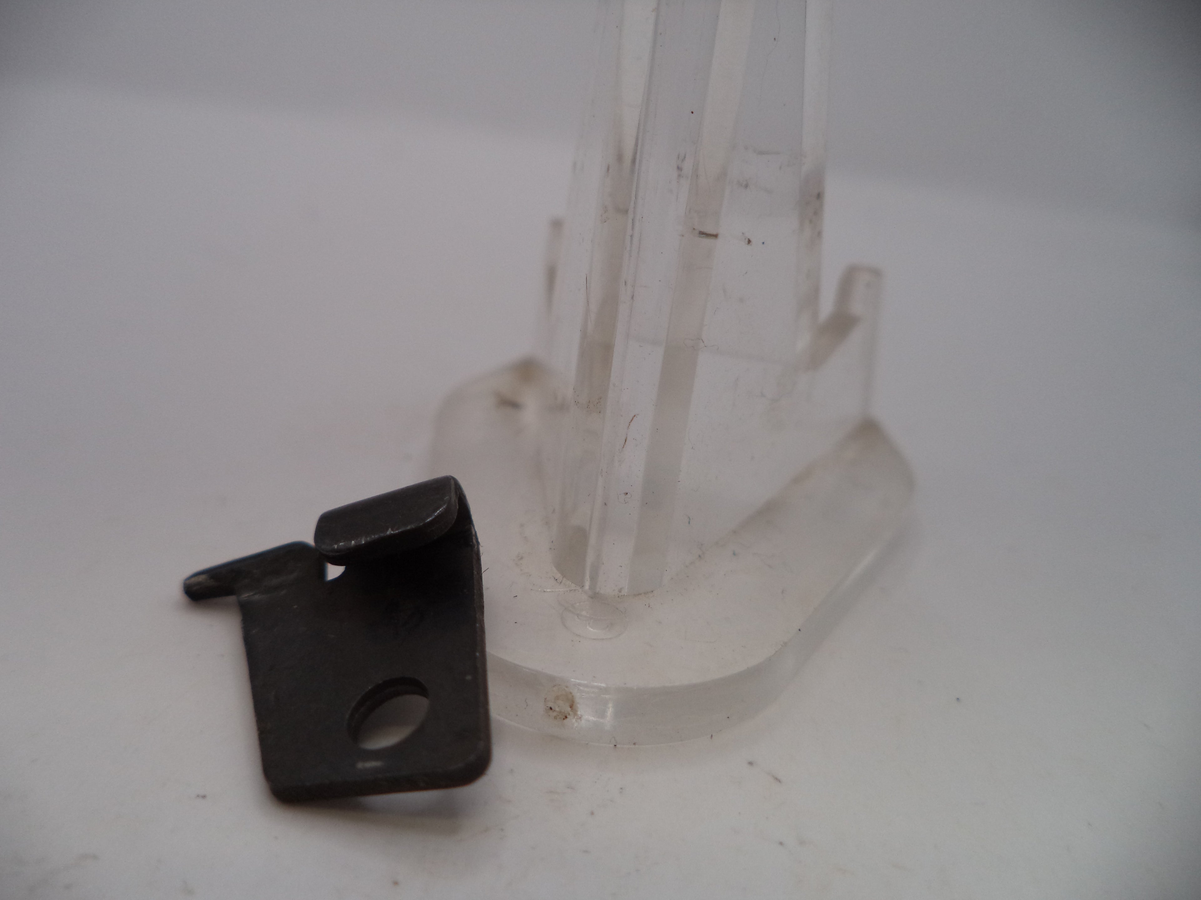 Black plastic clip and clear plastic stand on a white background