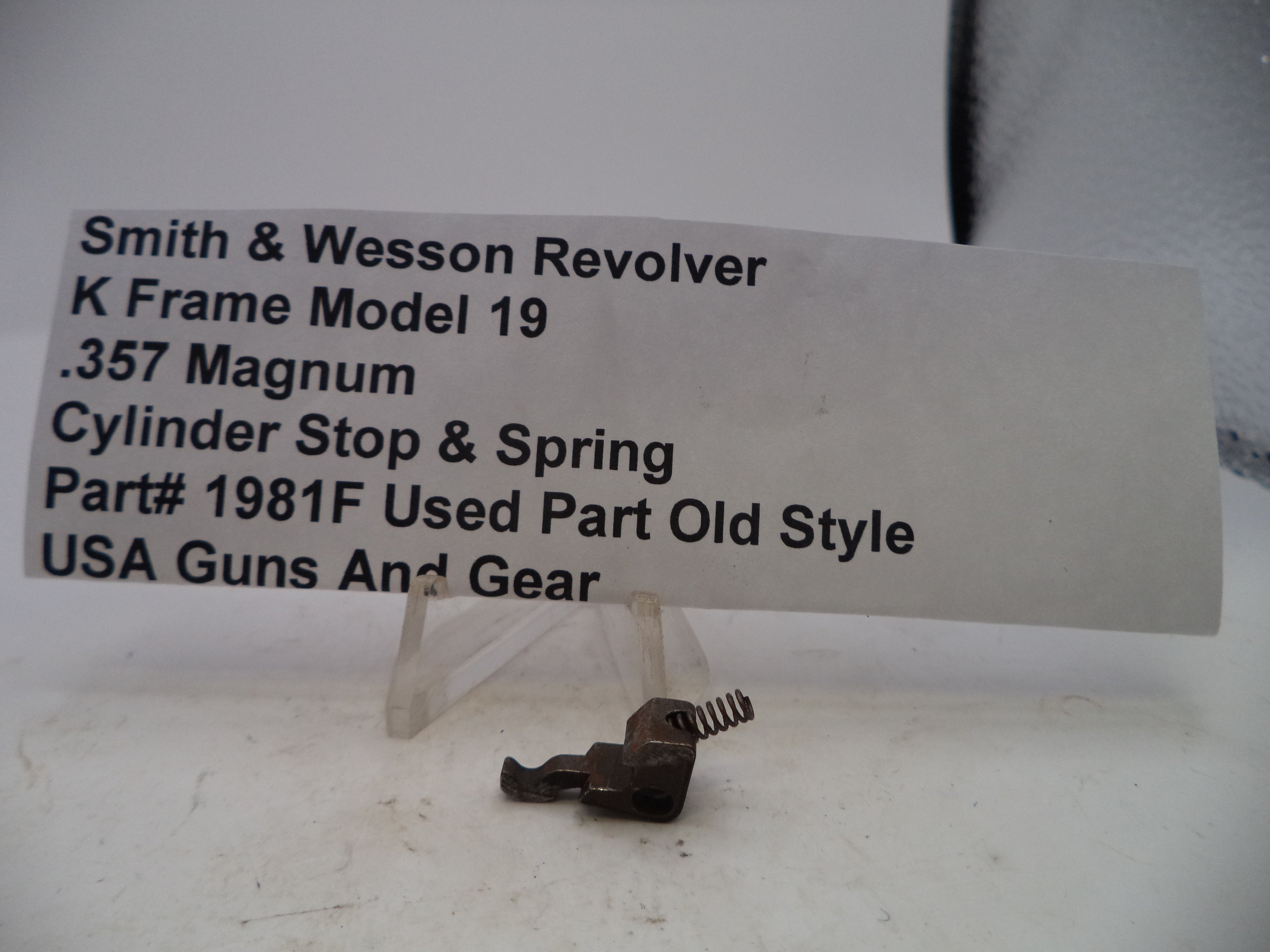 Smith & Wesson revolver cylinder stop and spring with descriptive label on a white background