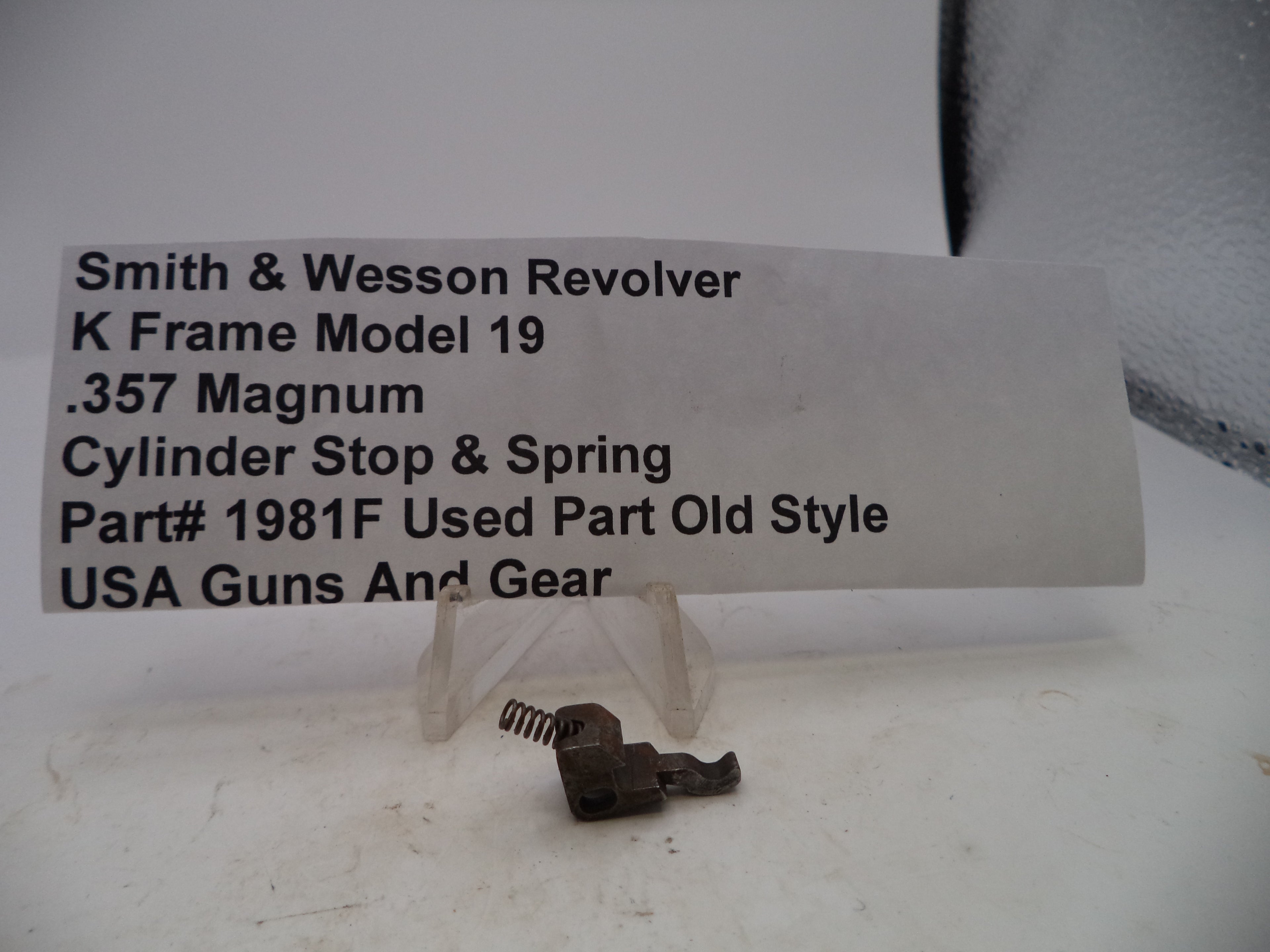 Smith & Wesson revolver parts on a white background with a label.