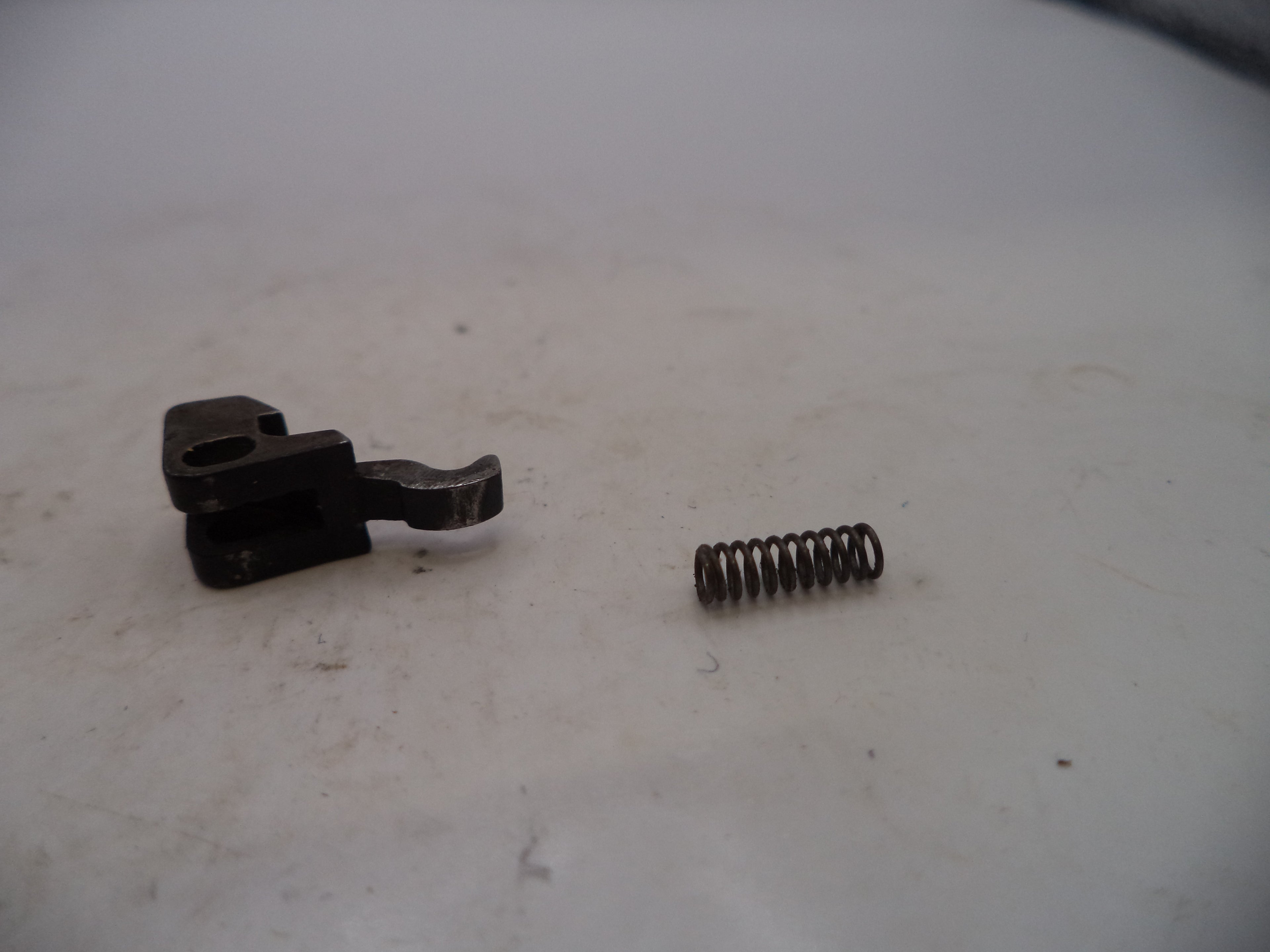Mechanical component and spring on a white surface