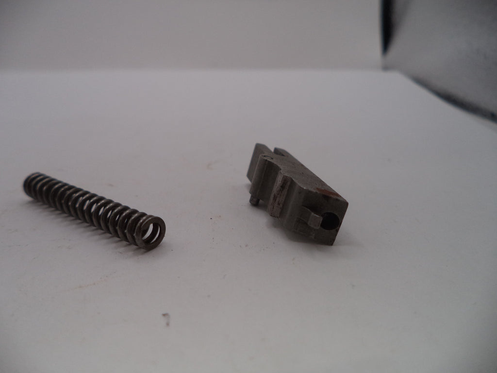 Metal spring and brown component on a white surface