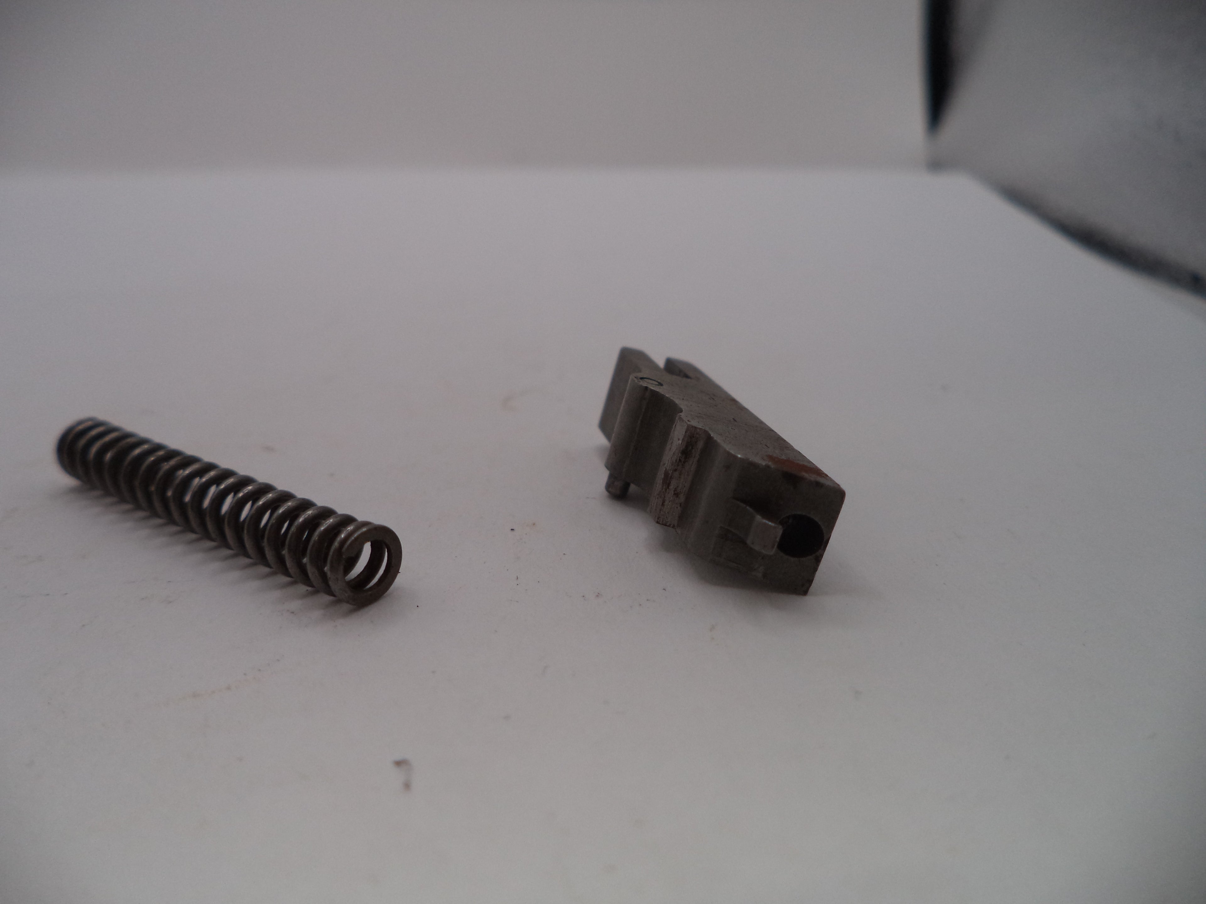 Metal spring and brown component on a white surface