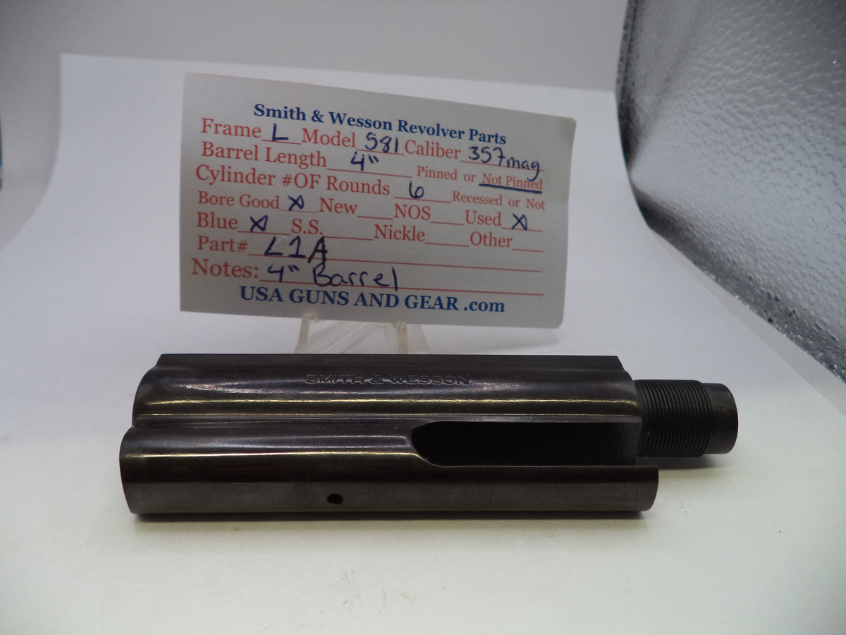 A black metal Smith & Wesson revolver barrel part displayed on a white surface with a branded parts card behind it.