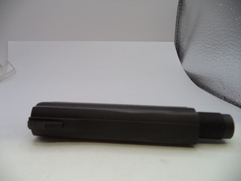 A black cylindrical plastic tool, possibly a grip sleeve or handle component, shown horizontally on a white surface with a textured gray backdrop.