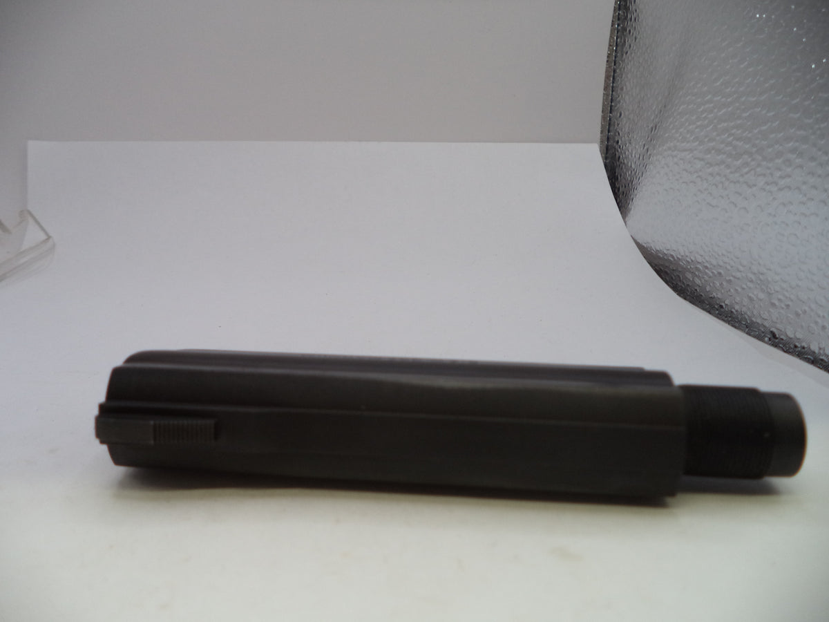 A black cylindrical plastic tool, possibly a grip sleeve or handle component, shown horizontally on a white surface with a textured gray backdrop.