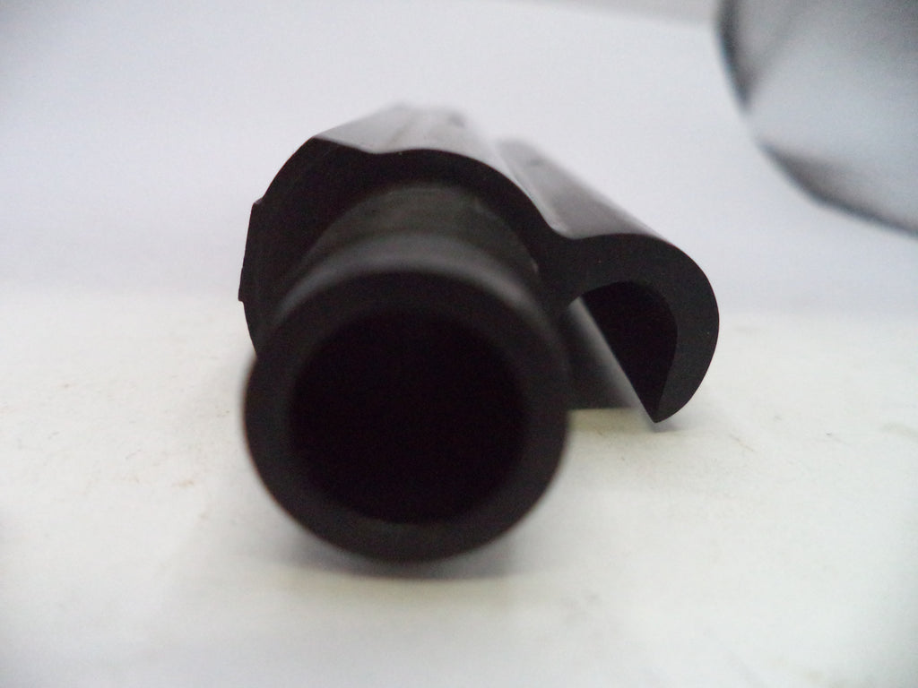 A close-up of a black plastic cylindrical component with a curved side tab, photographed on a plain light background.