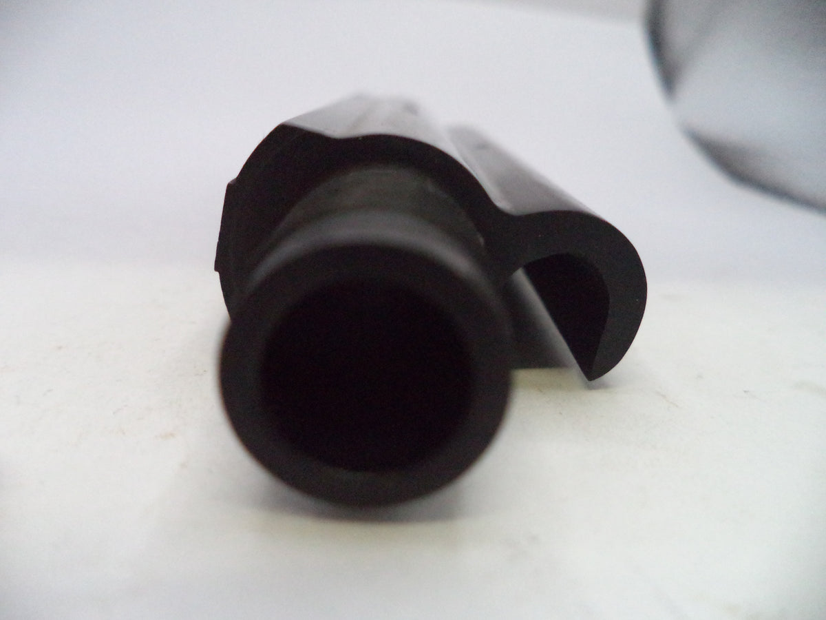 A close-up of a black plastic cylindrical component with a curved side tab, photographed on a plain light background.