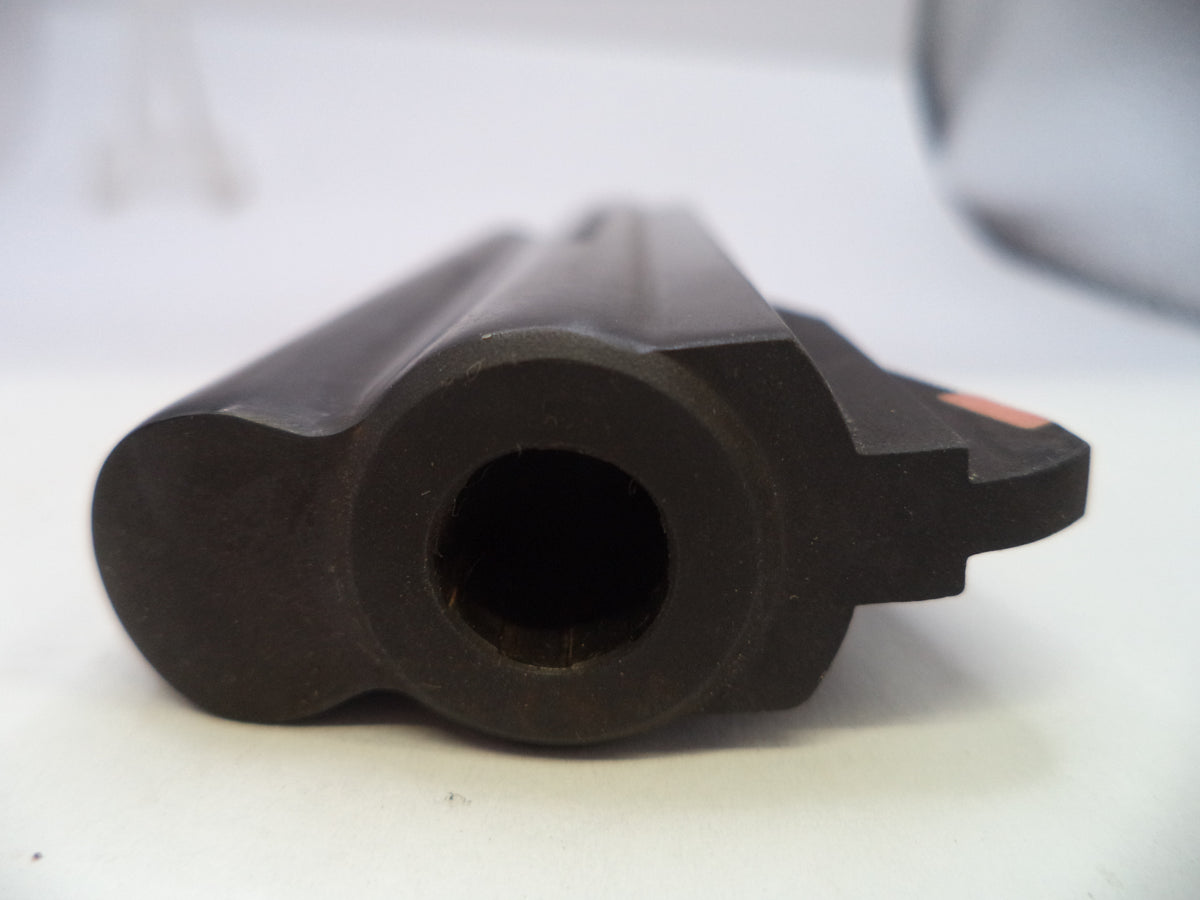 A close-up shot of a black plastic or rubber cylindrical component with a circular opening, photographed on a white surface with a blurred background.