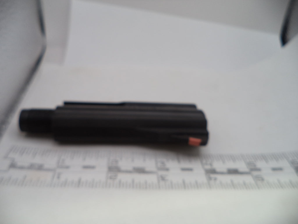 A black cylindrical pen-like tool with a small orange accent, photographed on a white surface next to a ruler for scale.