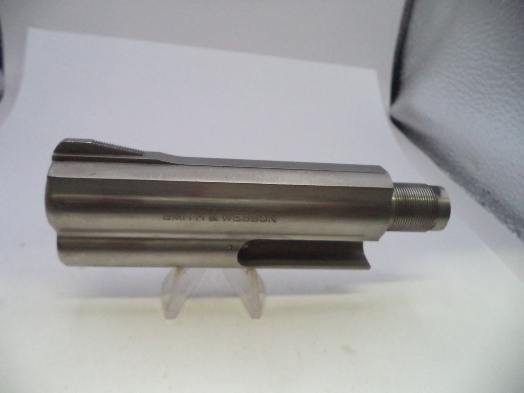 A metallic cylindrical tool component with a threaded end, photographed on a white surface with a small clear stand. The engraved text 'SMITH & WESSON' is visible on the side.