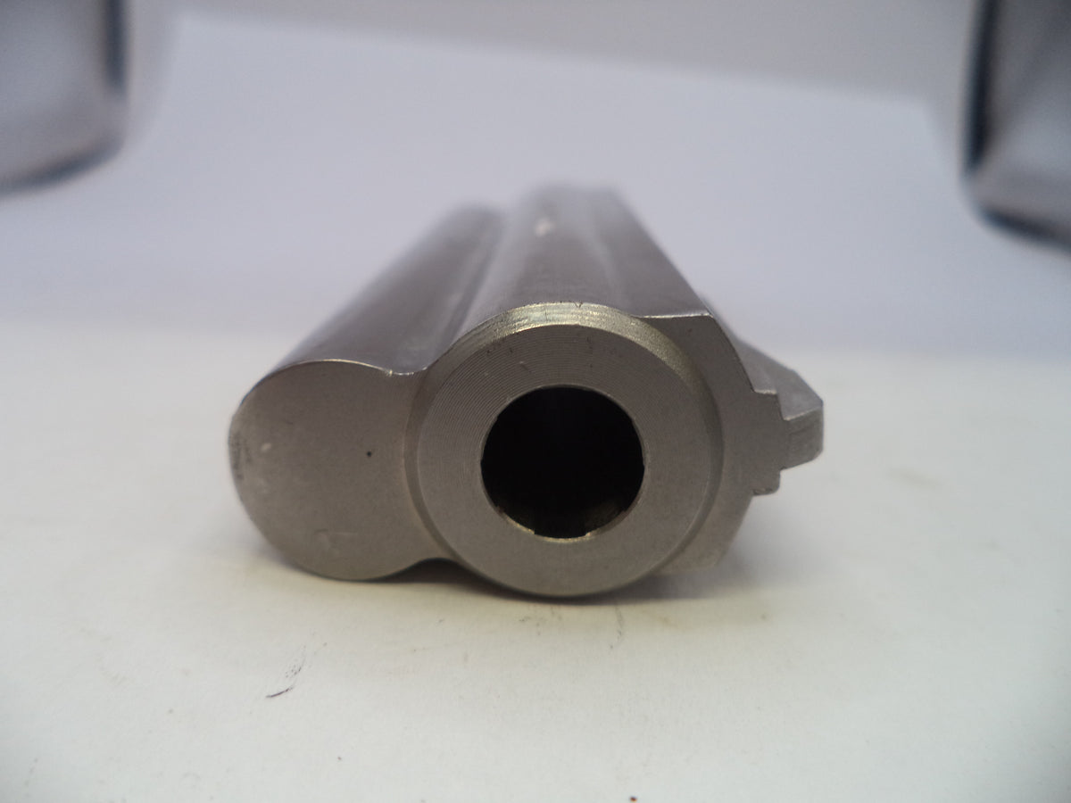 A close-up shot of a metallic gun barrel muzzle, showing the smooth bore and surrounding casing details on a plain white surface.