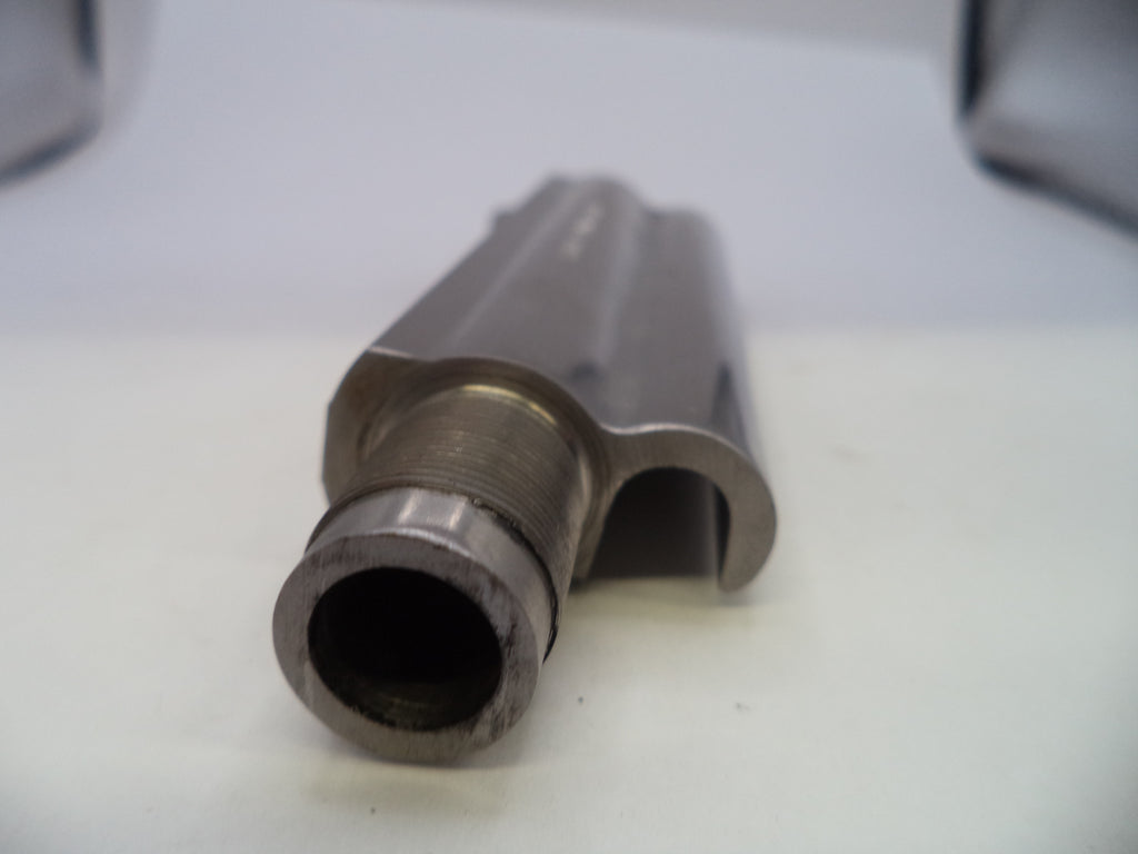 A close-up shot of a metallic cylindrical component with a threaded opening, resting on a white surface.
