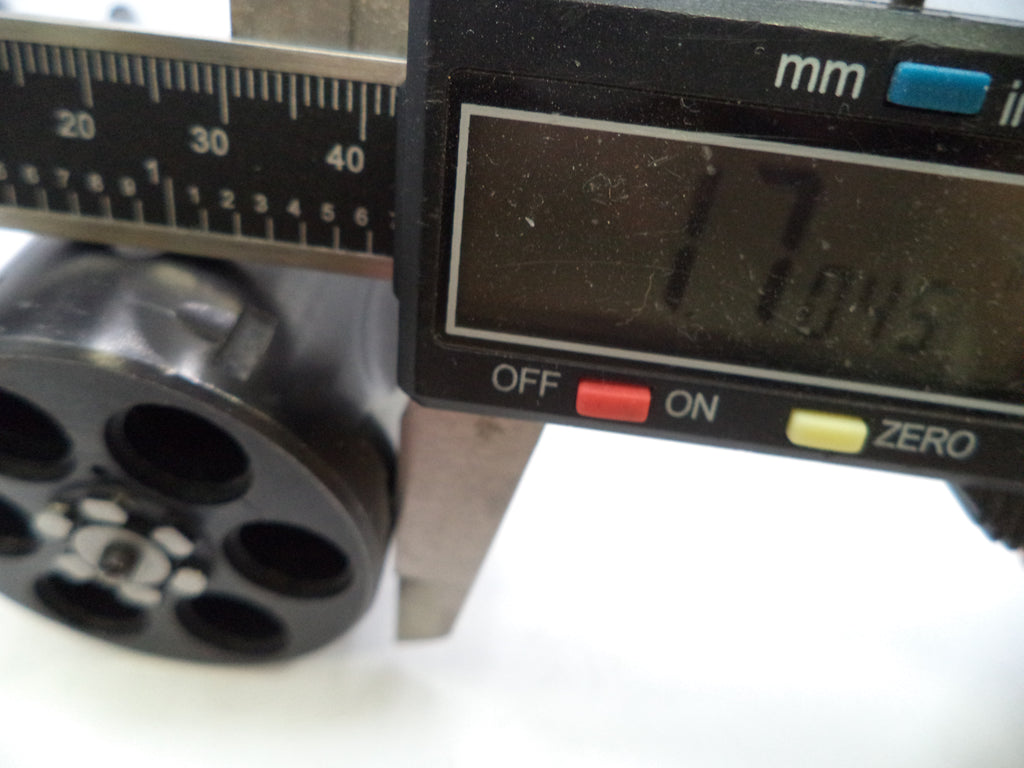 Close-up of a digital caliper measuring the diameter of a black cylindrical component, with the display reading 17.045 mm.