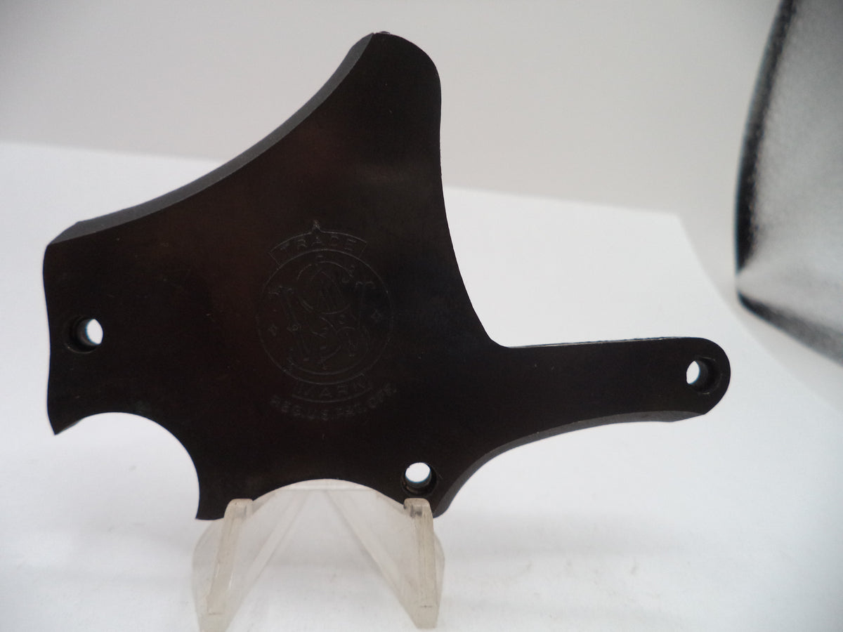 A dark brown wooden guitar headstock cover or decorative plaque with pre-drilled mounting holes, displayed on a clear plastic stand against a white background.