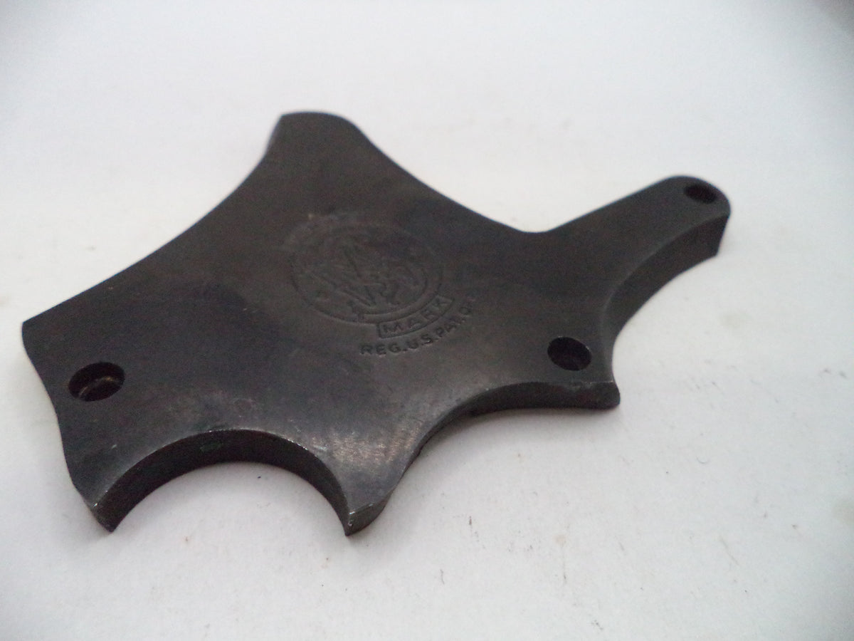A dark metal replacement part with a curved, multi-pronged shape and two screw holes, featuring an embossed circular logo in the center, shown on a plain white background.