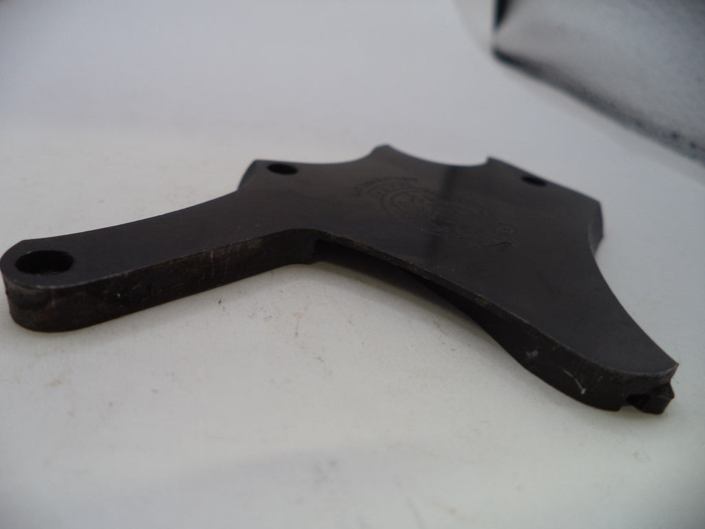 A dark metal mechanical part, likely a bracket or guide, photographed on a white surface.