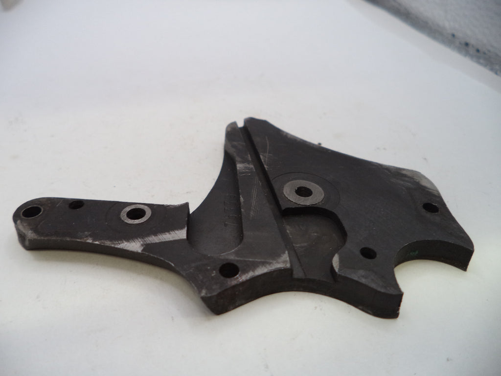 A dark gray or black molded plastic mechanical part with multiple pre-drilled holes, photographed on a plain white surface.