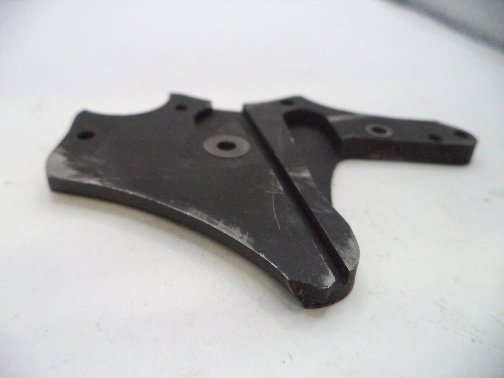 A black metal mechanical bracket or plate with pre-drilled holes and a central slot, photographed on a white surface.