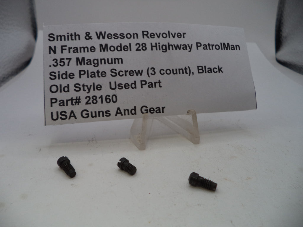 Three small black metal screws displayed on a white surface in front of a printed product information card for a Smith & Wesson revolver part.