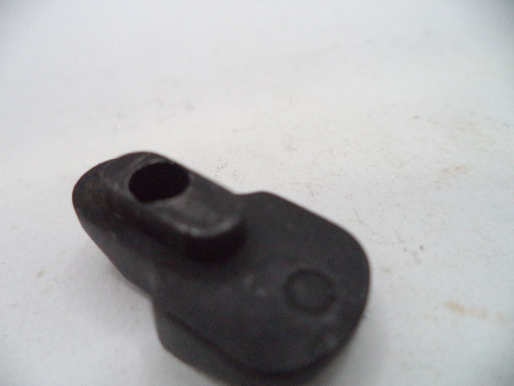 A small black plastic or rubber component with a rounded rectangular shape, a central hole, and a circular recess, photographed on a light off-white background.