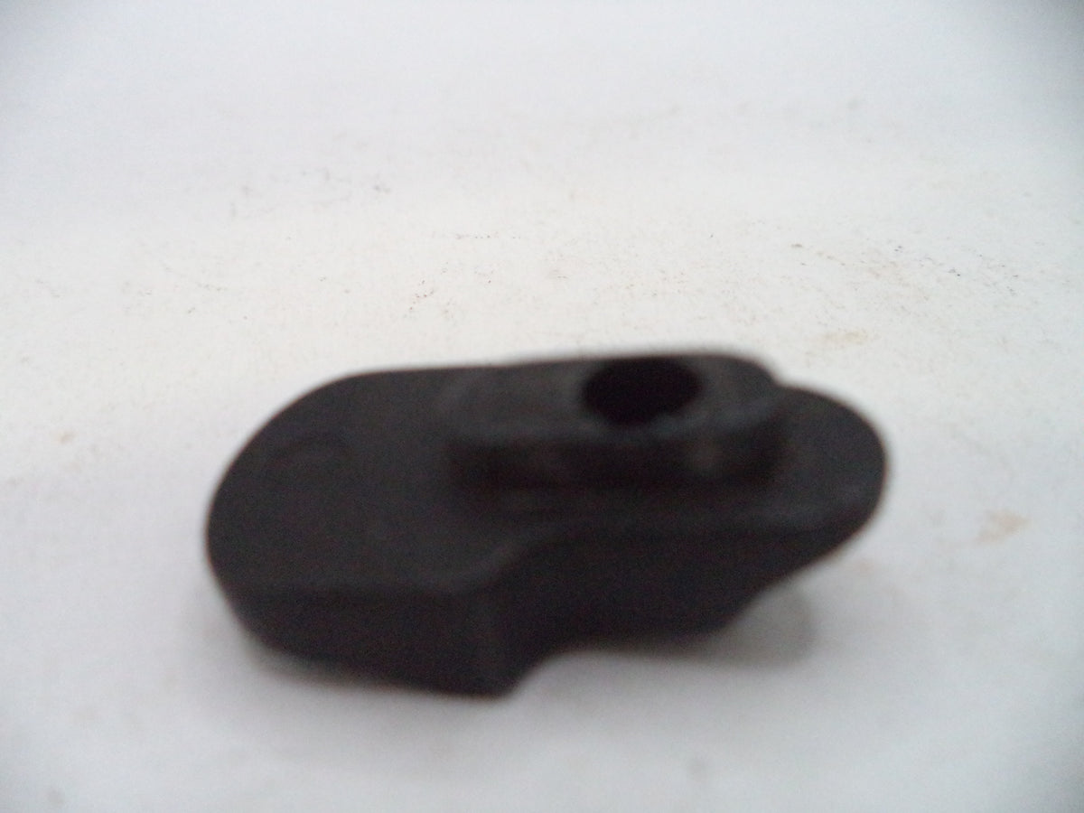 A small black plastic or rubber component with a central hole, photographed on a plain off-white background.
