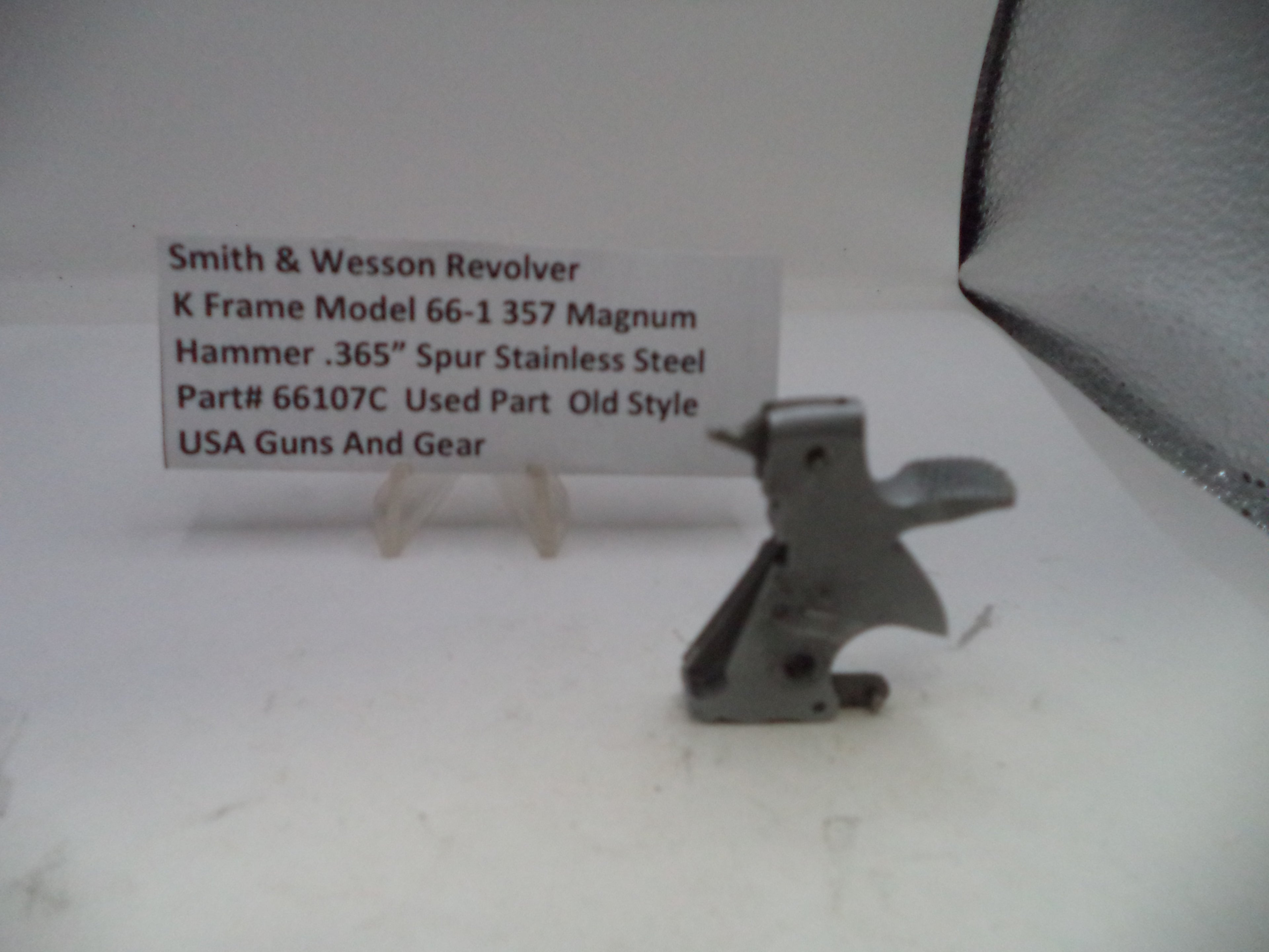 Smith & Wesson revolver part on a white surface with descriptive text card.