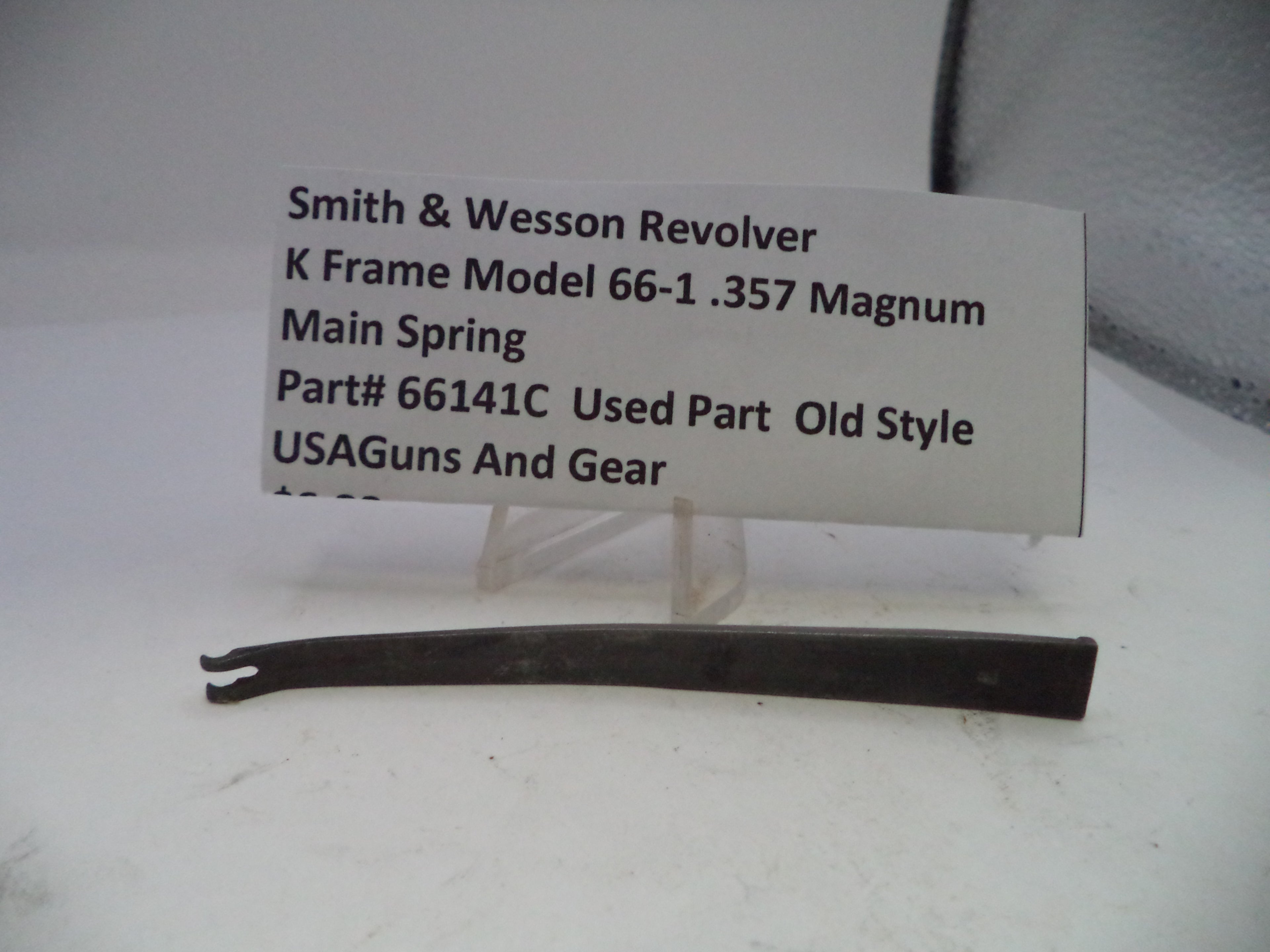 Smith & Wesson revolver main spring with a label on a white background