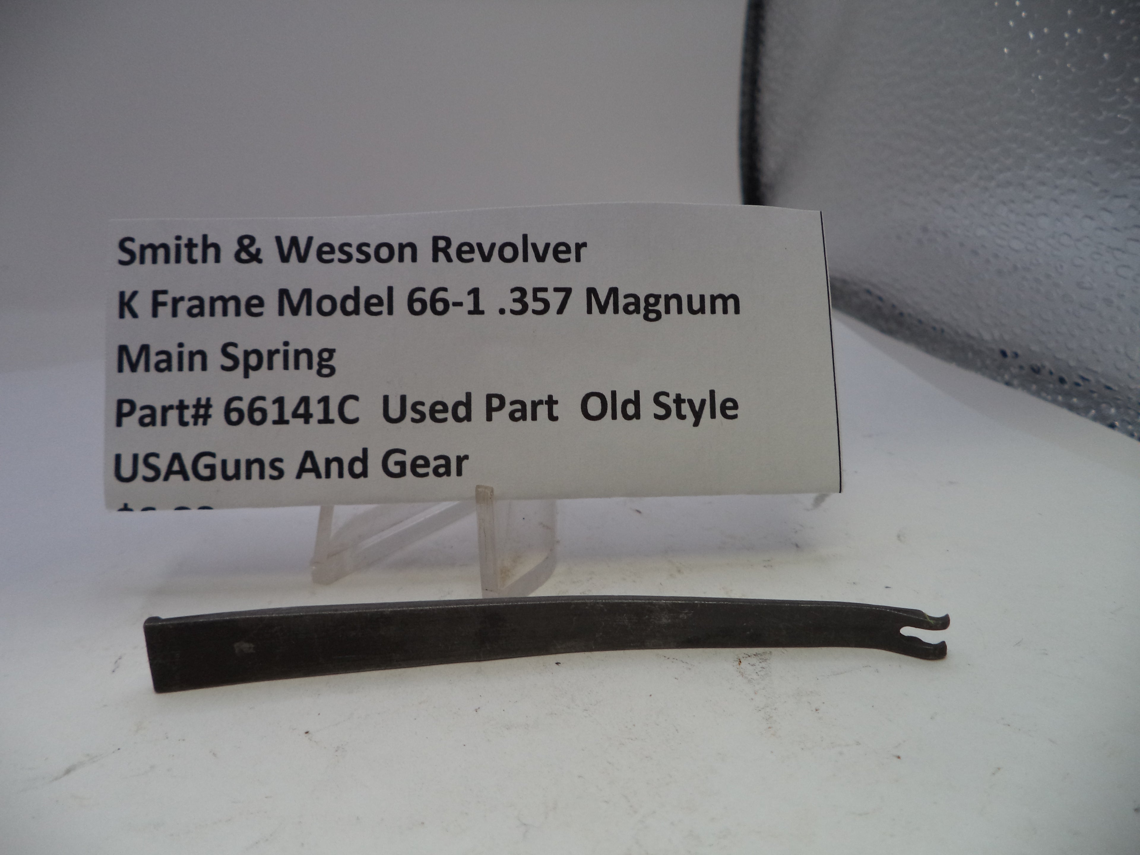 Smith & Wesson revolver main spring with descriptive label on a white background