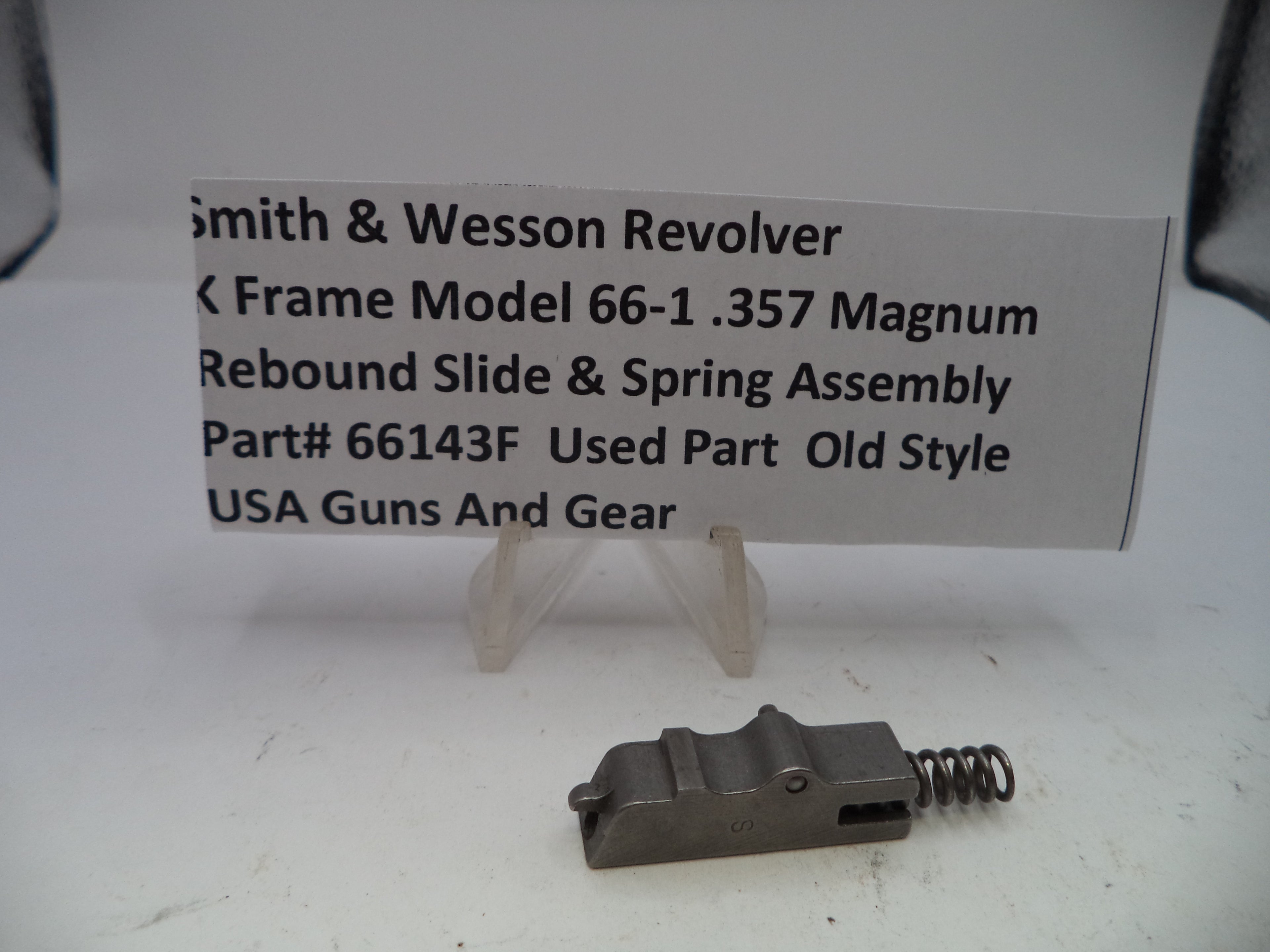 Smith & Wesson revolver slide and spring assembly with a label on a white background