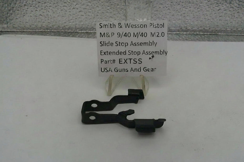 Smith & Wesson pistol slide stop assembly with a label on a white surface