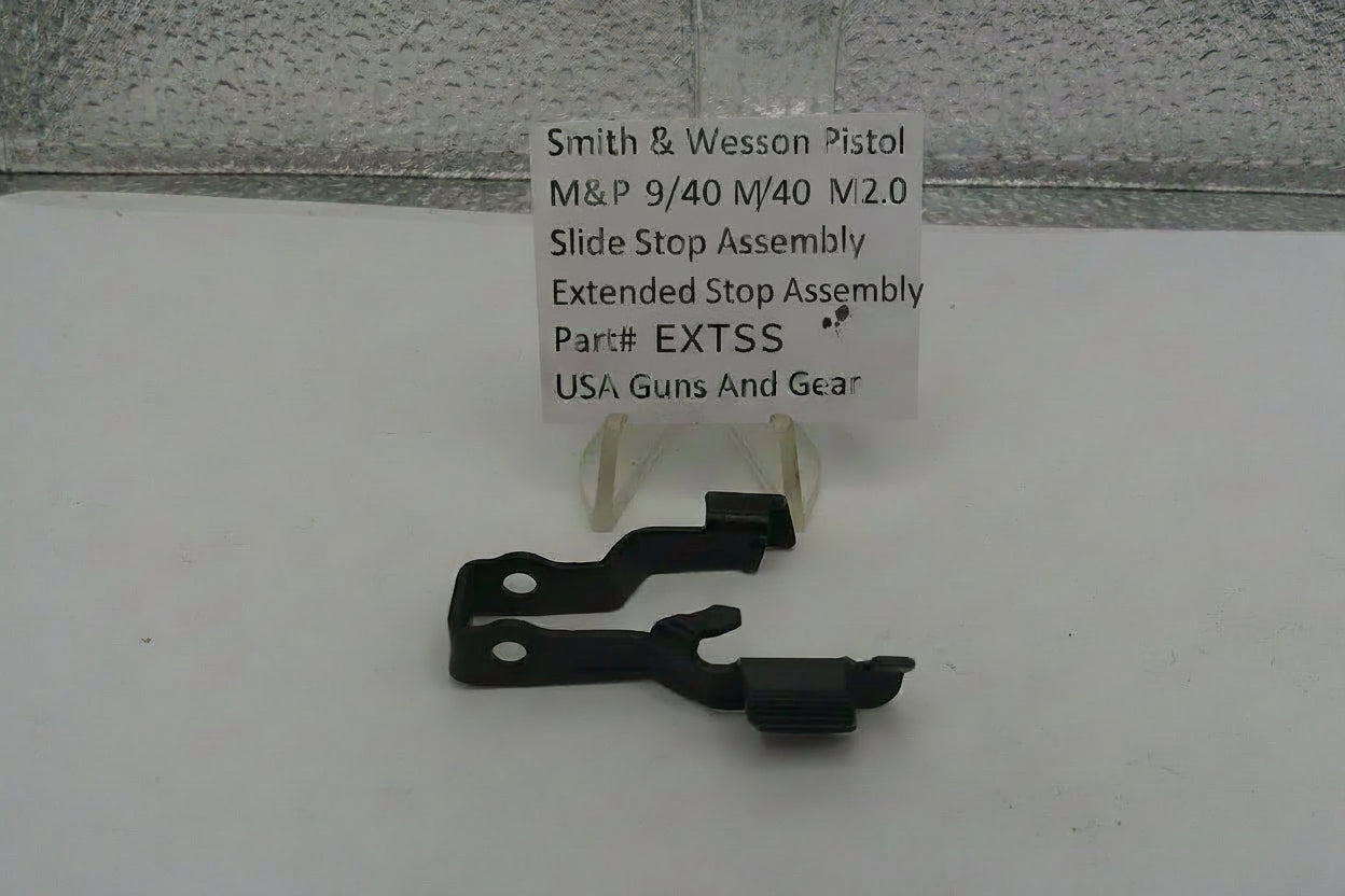 Smith & Wesson pistol slide stop assembly with a label on a white surface