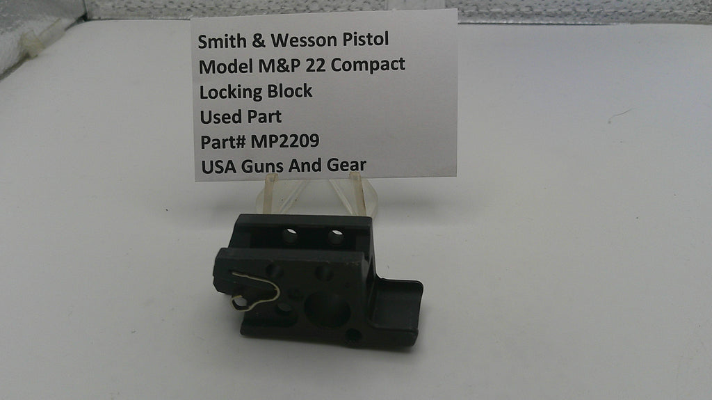Smith & Wesson pistol part on a white surface with a label
