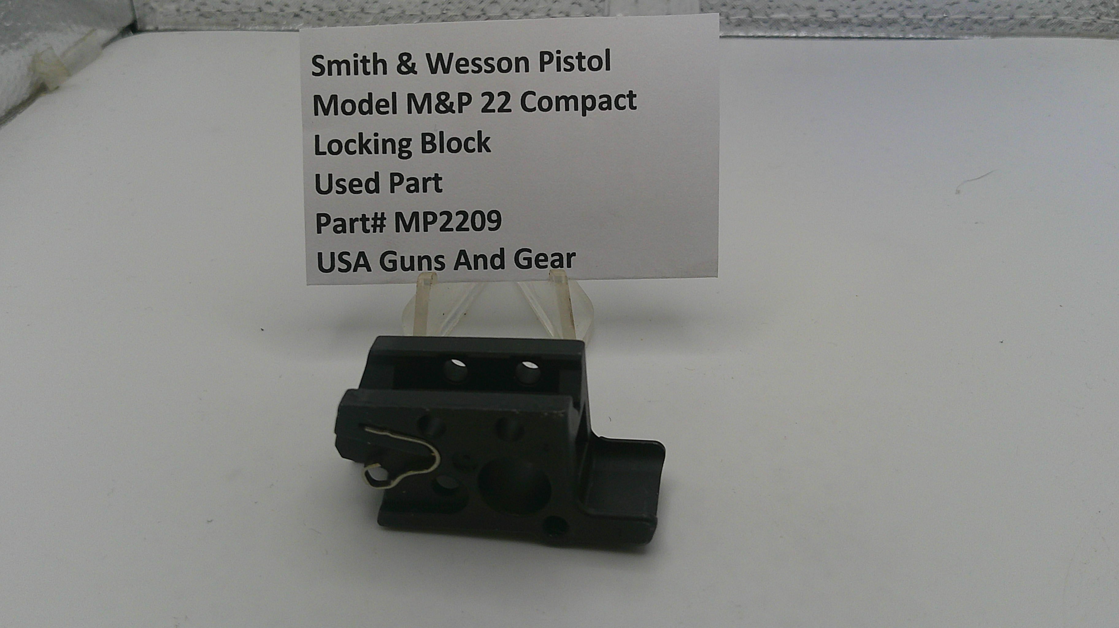 Smith & Wesson pistol part on a white surface with a label