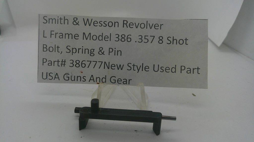 A used black metal Smith & Wesson revolver bolt, spring, and pin part, displayed on a small clear stand with a paper label card behind it on a white background.
