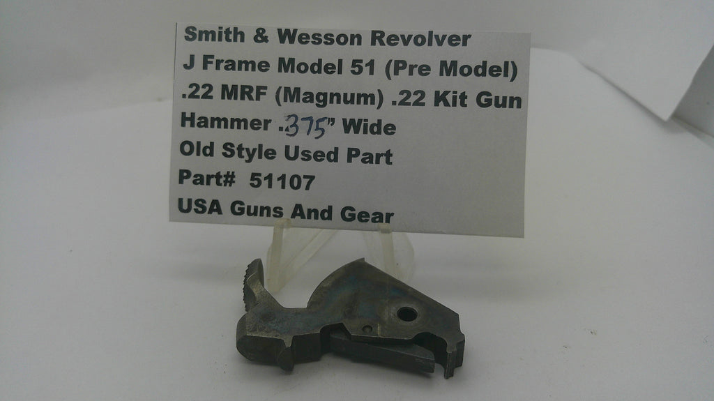 A used metal firearm part displayed on a small stand in front of a white sign that reads 'Smith & Wesson Revolver J Frame Model 51 (Pre Model) .22 MRF (Magnum) .