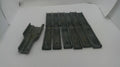 A set of dark gray metal or plastic replacement parts, including one larger piece on the left and several long narrow strips on the right, displayed on a white background.