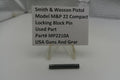 Smith & Wesson pistol part with a label on a white background