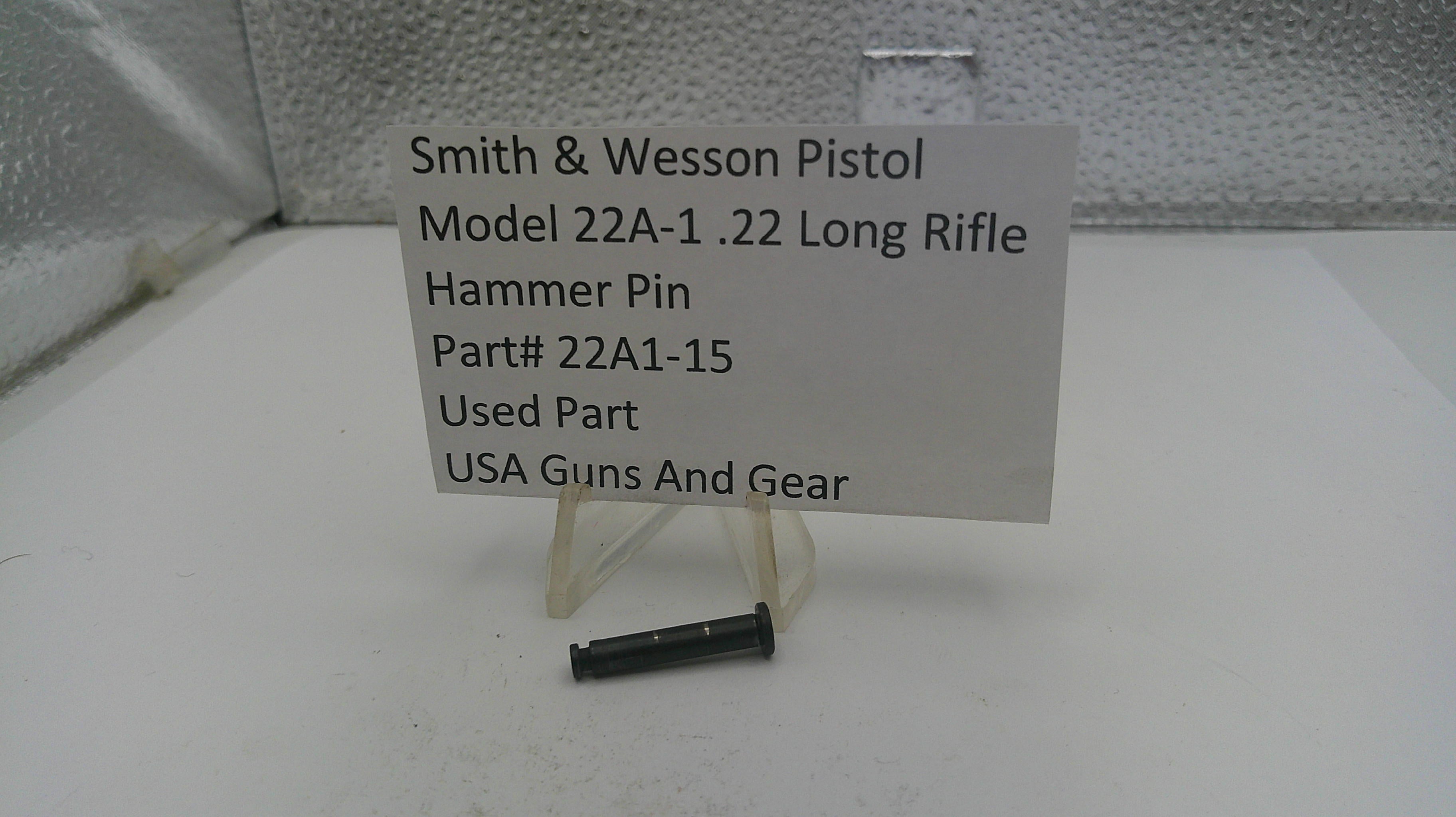 Smith & Wesson Pistol Hammer Pin on a stand with a label indicating part number and source.