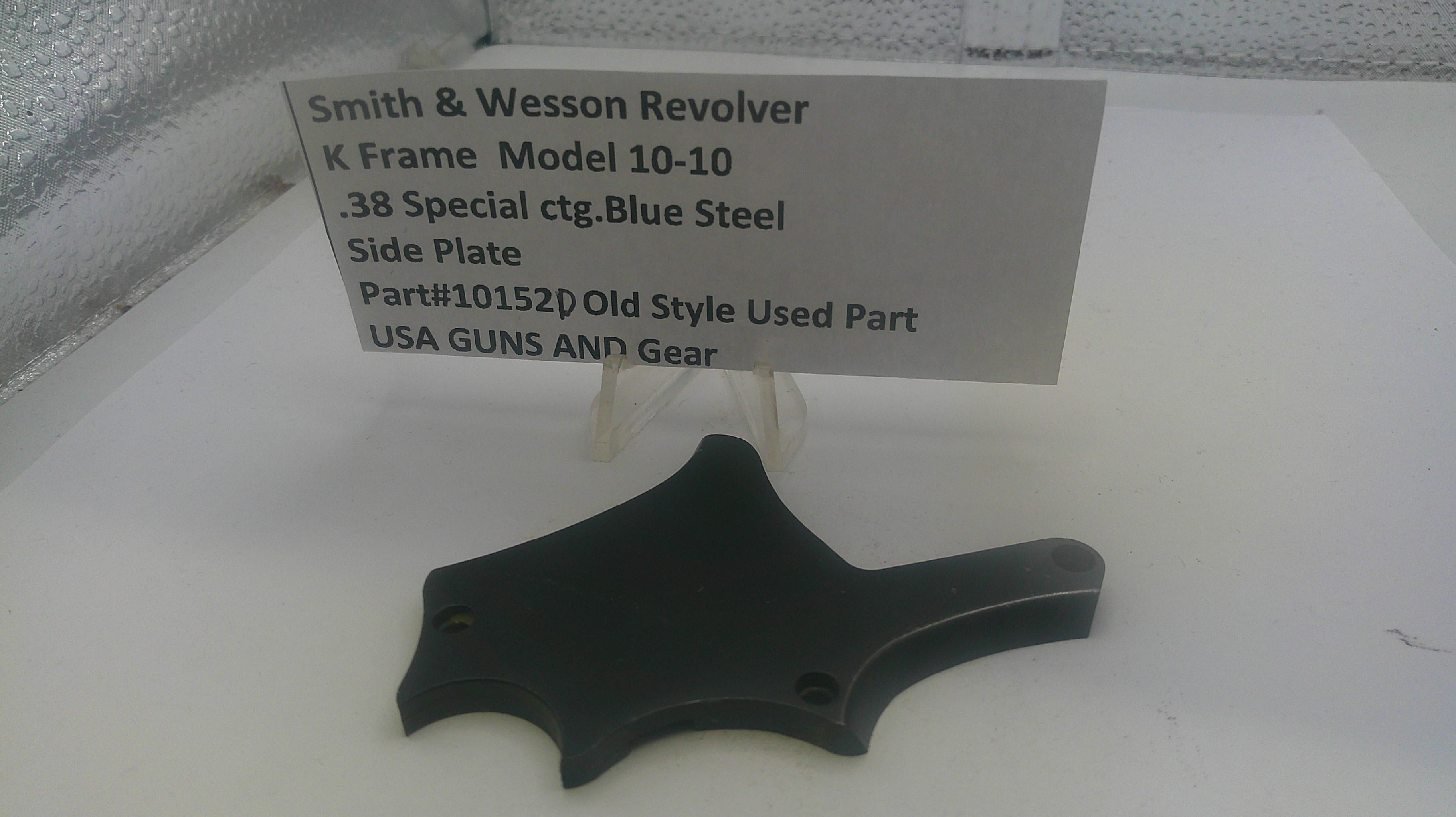 Black side plate for a Smith & Wesson revolver on a white surface with a label.