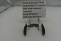 Smith & Wesson pistol slide stop assembly on a white surface with a label.