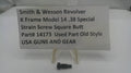 A small black metal strain screw part displayed below a white sign that reads 'Smith & Wesson Revolver K Frame Model 14 .38 Special Strain Screw Square Butt Part# 14173 Used Part Old Style USA GUNS AND GEAR' on a white surface.